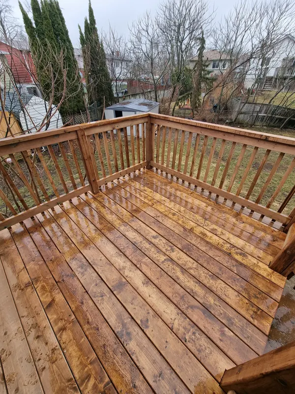 Completed pressure treated deck with railing after spring rain